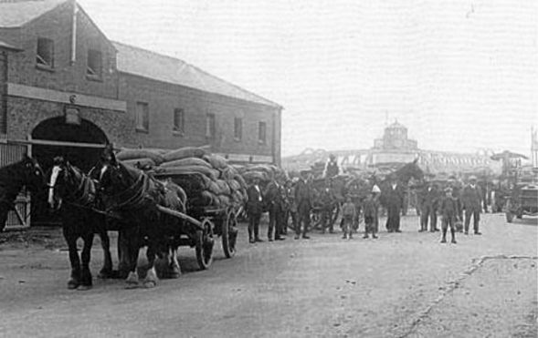 AOS P 2766 Garner’s Wharf,two-storey warehouse was built between 1836 and 1850,The Warehouse .1910, horses and carts laden with corn sacks waiting to be shipped. (2)